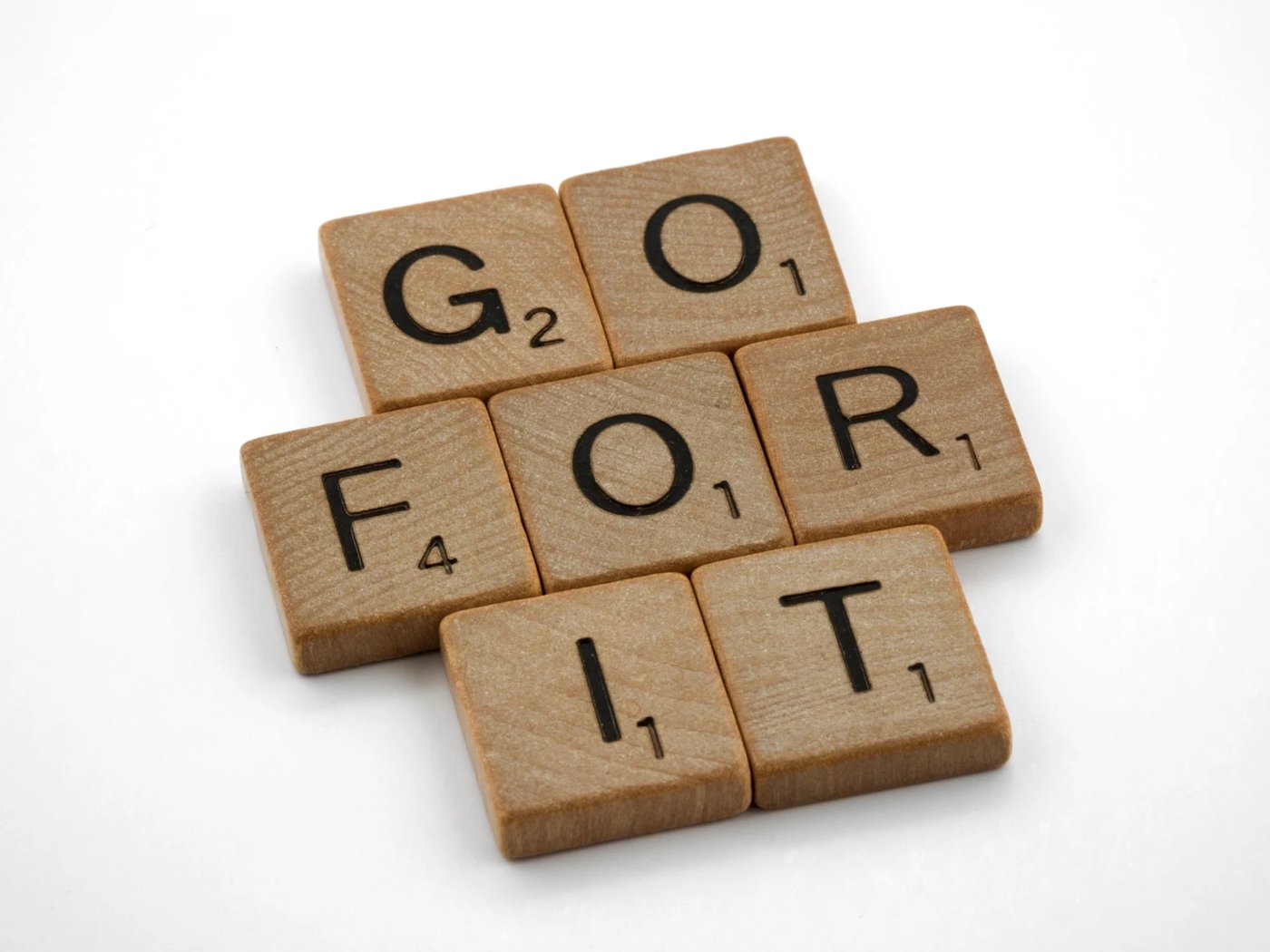Scrabble tiles spelling the words GO FOR IT